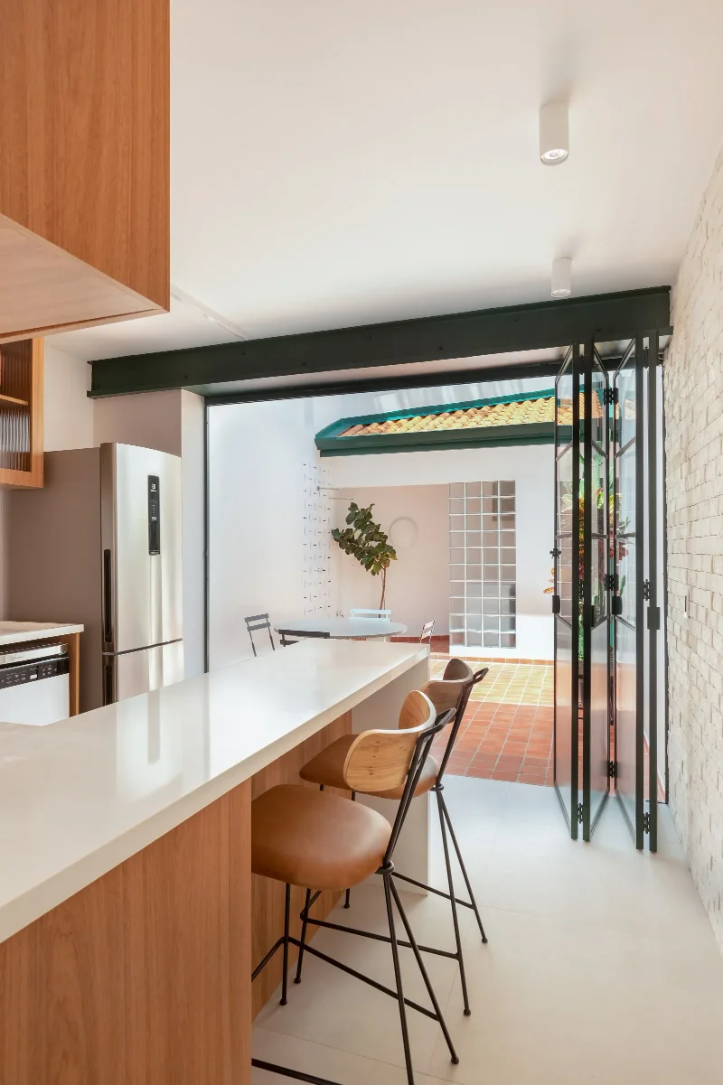 Projeto: Estúdio Maré | A cozinha ganha protagonismo na casa com a integração ao quintal por meio de uma abertura que fa