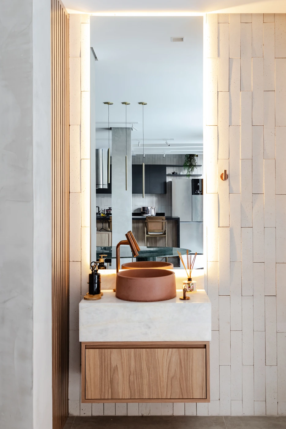 Projeto: Giovanna Caliman | No lavabo, quartzito translúcido, concreto terracota e freijó criam uma composição marcante